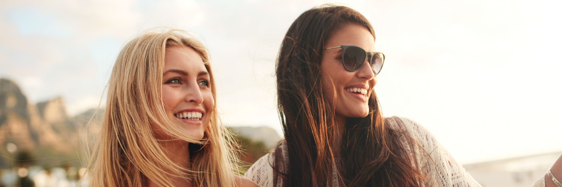 Two beautiful young women with perfect smiles enjoying a day outdoors.