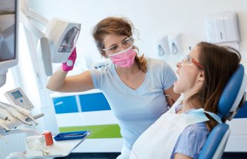 A dentist and a woman in a dental chair during an emergency dental appointment.
