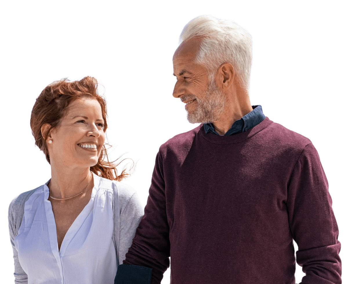 Happy smiling mature couple walking on the beach in a sunny day.