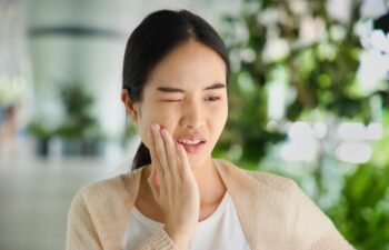Young Asian woman suffering from toothache, tooth decay, tooth sensitivity, wisdom tooth pain, cavity, dental care concept